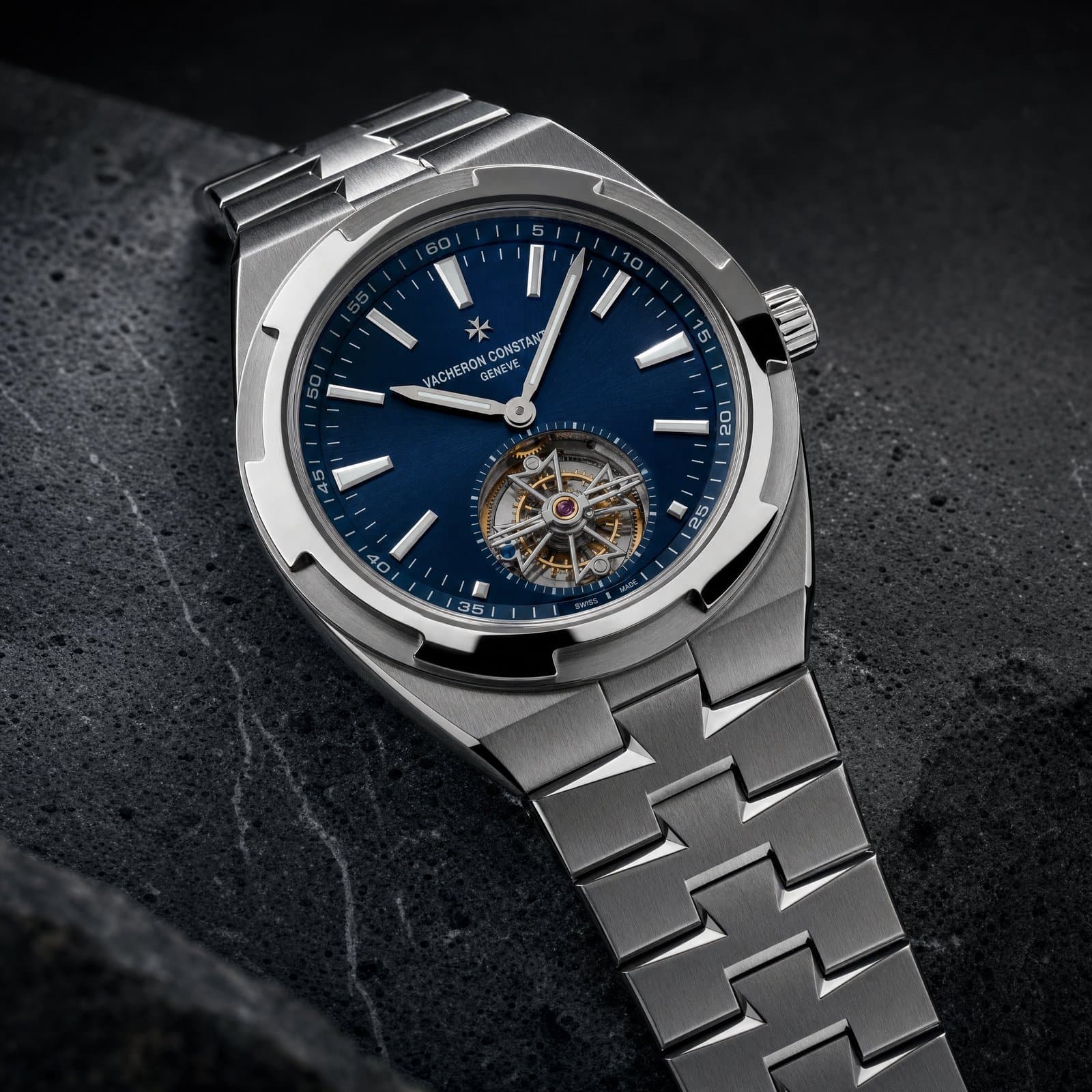 Macro of a blue-dial steel Overseas on dark travertine